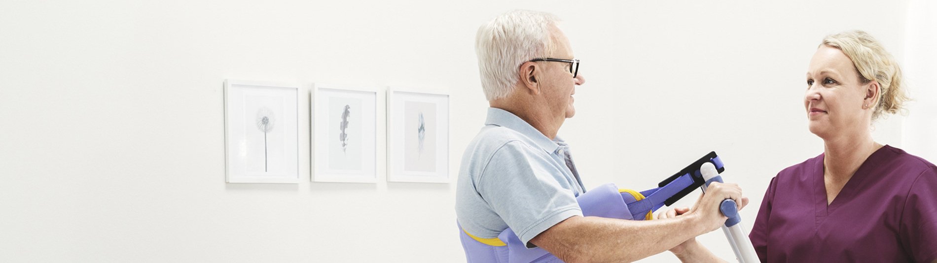 A nurse stands beside a bariatric patient in a hygiene area, with Arjo equipment visible in a clean clinical setting designed for patient handling and comfort.