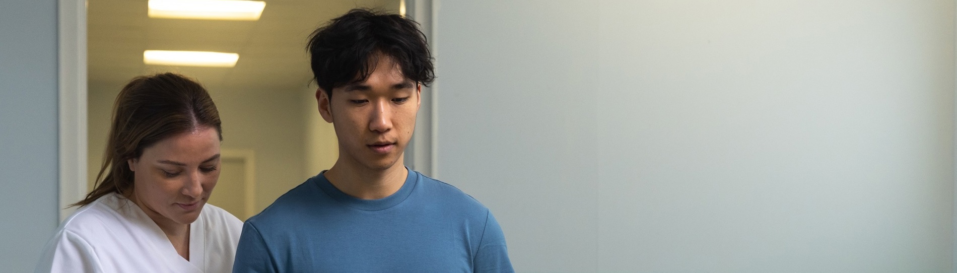 Medical staff supporting a person during physical rehabilitation in a clinical setting