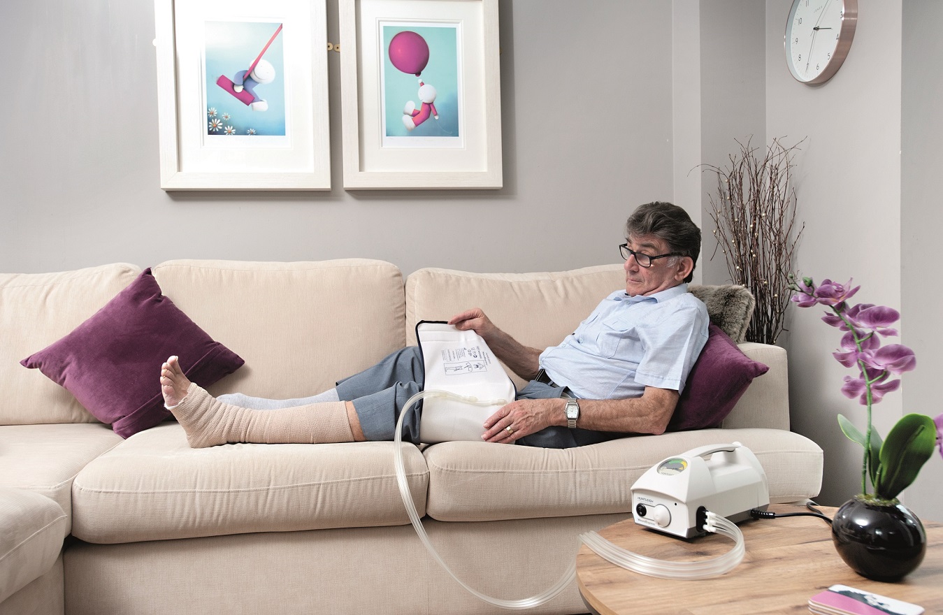 Arjo Woundexpress Bewohner mit Manschette auf Couch